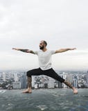 Concept de dessus de toit de yoga de pratique en matière d'homme photo stock Concept de dessus de toit de yoga de pratique en matière d'homme photo stock