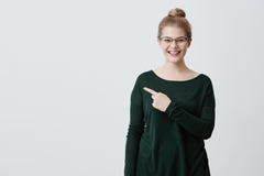 Concept de publicité Jeune dame avec les cheveux blonds, l'eyewear élégant dans le chandail vert et l'expression rieuse photographie stock Concept de publicité Jeune dame avec les cheveux blonds, l'eyewear élégant dans le chandail vert et l'expression rieuse photographie stock