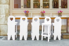 Wedding interior. Wedding design. Waiting for guests background. Attributes of holiday. Five white wooden chairs with