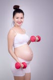 Concept enceinte d'exercices Un portrait d'une belle femme enceinte asiatique faisant l'exersice léger à l'aide du dumbell à la m photos libres de droits Concept enceinte d'exercices Un portrait d'une belle femme enceinte asiatique faisant l'exersice léger à l'aide du dumbell à la m photos libres de droits