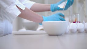 The concept of food quality control. Scientist breaks an egg in the laboratory. The process of preparing the product for