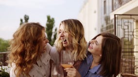 Concept of hen-party. Three beautiful women drinking cocktails together on a terrace. Women chatting and laughing. Slow stock video footage Concept of hen-party. Three beautiful women drinking cocktails together on a terrace. Women chatting and laughing. Slow stock video footage