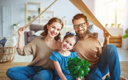 Concept logeant la jeune famille P?re et enfant de m?re dans la nouvelle maison avec le toit ? la maison photographie stock Concept logeant la jeune famille P?re et enfant de m?re dans la nouvelle maison avec le toit ? la maison photographie stock