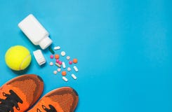 Concept preparing to fitness sports equipment and bottle of medicine on blue background. royalty free stock photography Concept preparing to fitness sports equipment and bottle of medicine on blue background. royalty free stock photography