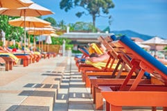 Concept of relaxing sunbathing by the water. Sun loungers by the outdoor pool. Sunny summer afternoon. Prospect. Copy space. royalty free stock image Concept of relaxing sunbathing by the water. Sun loungers by the outdoor pool. Sunny summer afternoon. Prospect. Copy space. royalty free stock image