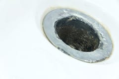 Small DOF. Damaged sewer hole with corrosion elements in a white bath, washbasin or shower. Concept on repairing stock photography Small DOF. Damaged sewer hole with corrosion elements in a white bath, washbasin or shower. Concept on repairing stock photography