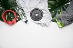 Concept sportenlevensstijl, sportkleding en toebehoren op een witte achtergrond, met fles van water en tropische bladeren wordt o royalty-vrije stock afbeelding Concept sportenlevensstijl, sportkleding en toebehoren op een witte achtergrond, met fles van water en tropische bladeren wordt o royalty-vrije stock afbeelding