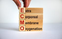 Concept words `ECMO, Extra Corporeal Membrane Oxygenation` on cubes and blocks on a beautiful white background. Male hand. Copy