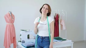 Concepto de afici?n y de peque?a empresa Sastre de sexo femenino joven hermoso que sonr?e en la c?mara almacen de video Concepto de afici?n y de peque?a empresa Sastre de sexo femenino joven hermoso que sonr?e en la c?mara almacen de video