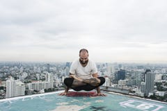 Concepto del tejado de la yoga de la práctica del hombre fotografía de archivo Concepto del tejado de la yoga de la práctica del hombre fotografía de archivo