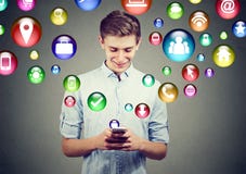 Concetto alta tecnologia di tecnologia mobile Giovane felice che per mezzo dello Smart Phone con le icone dell'applicazione socia Immagini Stock Concetto alta tecnologia di tecnologia mobile Giovane felice che per mezzo dello Smart Phone con le icone dell'applicazione socia Immagini Stock