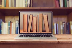 Concetto della biblioteca del libro elettronico con il computer portatile ed i libri Concetto della biblioteca del libro elettronico con il computer portatile ed i libri