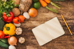 Concetto delle classi di cottura Ortaggi freschi intorno al taccuino aperto o fotografie stock Concetto delle classi di cottura Ortaggi freschi intorno al taccuino aperto o fotografie stock