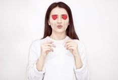 Concetto di amore di giorno di S. Valentino bello Ragazza felice che tiene due cuori sui suoi occhi fotografie stock Concetto di amore di giorno di S. Valentino bello Ragazza felice che tiene due cuori sui suoi occhi fotografie stock