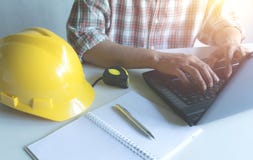 Concetto di lavoro dell'ingegnere dell'architetto con il computer portatile e la costruzione immagine stock libera da diritti Concetto di lavoro dell'ingegnere dell'architetto con il computer portatile e la costruzione immagine stock libera da diritti