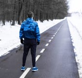 Condizione dell'uomo sull'eseguire pista e sul considerarla prima del funzionamento di mattina fotografia stock Condizione dell'uomo sull'eseguire pista e sul considerarla prima del funzionamento di mattina fotografia stock