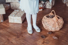 Condizione della ragazza all'albero di Natale Sul pavimento di legno c'è una scatola con i regali Le gambe sono vestite nei calzi fotografia stock Condizione della ragazza all'albero di Natale Sul pavimento di legno c'è una scatola con i regali Le gambe sono vestite nei calzi fotografia stock