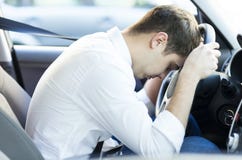 Conductor agotado que descansa sobre el volante imagenes de archivo Conductor agotado que descansa sobre el volante imagenes de archivo