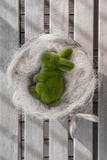 Conejito de pascua que miente en un arco, banco blanco del lavado, fondo de madera fotografía de archivo libre de regalías Conejito de pascua que miente en un arco, banco blanco del lavado, fondo de madera fotografía de archivo libre de regalías
