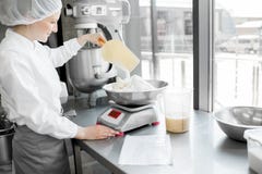 Confettiere della donna che lavora alla fabbricazione del forno fotografia stock Confettiere della donna che lavora alla fabbricazione del forno fotografia stock