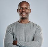 Confident black man with pleasant smile in gray stock photo Confident black man with pleasant smile in gray stock photo