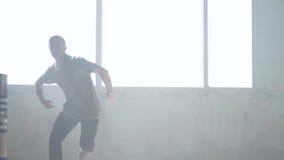 Confident young passionate hip-hop dancer performing in the fog. Hip hop culture. Rehearsal. Contemporary. stock footage Confident young passionate hip-hop dancer performing in the fog. Hip hop culture. Rehearsal. Contemporary. stock footage