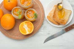 Confiture d'oranges dans un pot en verre sur un fond clair avec des pains grillés Avec l'espace vide pour l'inscription image libre de droits Confiture d'oranges dans un pot en verre sur un fond clair avec des pains grillés Avec l'espace vide pour l'inscription image libre de droits