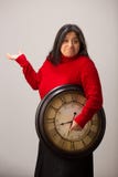 Confused Hispanic Woman Holds Clock Under Arm Unaware Of Future stock images Confused Hispanic Woman Holds Clock Under Arm Unaware Of Future stock images