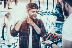 Conseiller Helps Guy Choose Helmet pour des tours de vélo images stock Conseiller Helps Guy Choose Helmet pour des tours de vélo images stock
