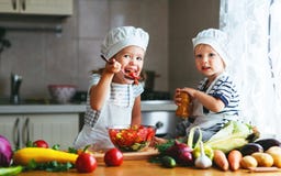 Consommation saine Les enfants heureux prépare la salade végétale dans le kitc images libres de droits Consommation saine Les enfants heureux prépare la salade végétale dans le kitc images libres de droits