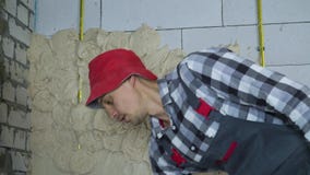 Constructeur dans l'usage de travail mettant le plâtre sur le mur aéré de bloc de béton clips vidéos Constructeur dans l'usage de travail mettant le plâtre sur le mur aéré de bloc de béton clips vidéos