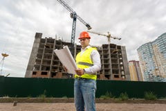 Construction engineer in hardhat on building site with working c royalty free stock photo Construction engineer in hardhat on building site with working c royalty free stock photo