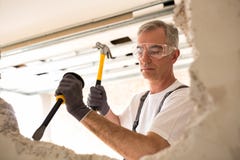 Construction worker holding tool and smash drywall Stock Photography Construction worker holding tool and smash drywall Stock Photography