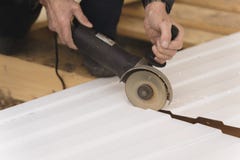 Construction worker sawing steel sheet with trapezoidal profile royalty free stock image Construction worker sawing steel sheet with trapezoidal profile royalty free stock image