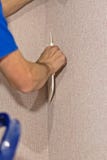 Construction worker uses a painting spatula to align the Wallpaper stock image Construction worker uses a painting spatula to align the Wallpaper stock image