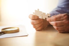 Construindo um sucesso comercial As mãos com enigmas fotografia de stock Construindo um sucesso comercial As mãos com enigmas fotografia de stock