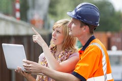 Construtor, mulher e portátil imagem de stock Construtor, mulher e portátil imagem de stock