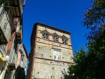 Construção velha com as janelas ascendentes embarcadas contra o céu azul no quadro de outras casas e árvores, Maratea, Itália imagens de stock Construção velha com as janelas ascendentes embarcadas contra o céu azul no quadro de outras casas e árvores, Maratea, Itália imagens de stock