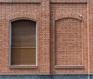 A construção é feita do tijolo no estilo do sótão A janela com cortinas e uma janela colocaram com tijolo foto de stock A construção é feita do tijolo no estilo do sótão A janela com cortinas e uma janela colocaram com tijolo foto de stock