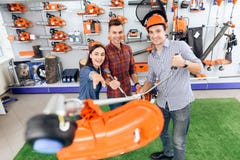 A consultant in a garden tools store shows a customer a grass cutter. royalty free stock image A consultant in a garden tools store shows a customer a grass cutter. royalty free stock image