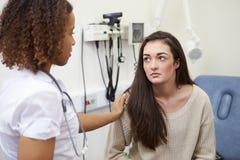 Consultor femenino Reassuring Teenage Patient en hospital imagen de archivo Consultor femenino Reassuring Teenage Patient en hospital imagen de archivo