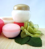 Containers Of Cosmetic Moisturizing Cream With Green Flower Royalty Free Stock Photography