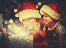 Contenitore di regalo magico di Natale e una neonata felice della madre e della figlia della famiglia fotografie stock Contenitore di regalo magico di Natale e una neonata felice della madre e della figlia della famiglia fotografie stock
