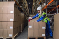 Contenitori di imballaggio del lavoratore del magazzino in deposito fotografia stock Contenitori di imballaggio del lavoratore del magazzino in deposito fotografia stock