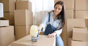 Contenitori di imballaggio domestici commoventi della giovane donna fotografie stock Contenitori di imballaggio domestici commoventi della giovane donna fotografie stock