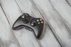 Contrôleur noir sans fil de gamepad ou de jeu pour le jeu de console sur la table en bois blanche photo stock Contrôleur noir sans fil de gamepad ou de jeu pour le jeu de console sur la table en bois blanche photo stock