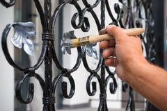 Contractor`s hand with brush that painting metal fence. Royalty Free Stock Photo Contractor`s hand with brush that painting metal fence. Royalty Free Stock Photo