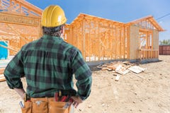 Contractor Standing Outside Construction Framing of New House. Royalty Free Stock Photos Contractor Standing Outside Construction Framing of New House. Royalty Free Stock Photos