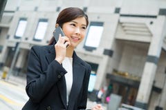 Conversazione asiatica della donna di affari al telefono cellulare fotografia stock Conversazione asiatica della donna di affari al telefono cellulare fotografia stock