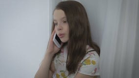 Conversazione emozionale della bella bambina sullo Smart Phone dalla finestra video d archivio Conversazione emozionale della bella bambina sullo Smart Phone dalla finestra video d archivio